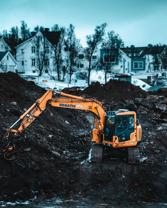 Home A powerful excavator operates at a Tromsø construction site during winter, showcasing heavy machinery.